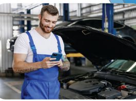 Wir liefern Ersatzteile über Nacht, deutschlandweit. Ein Mitarbeiter in einer Werkstatt bestellt über das Smartphone Ersatzteile.